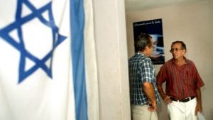 An Israeli flag hangs on the wall of the Jewish Community Center in Havana, Cuba, where two men are speaking on August 1, 2004. (Serge Attal/Flash90)