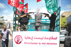 PFLP members aim their weapons at an effigy of Donald Trump in a Gaza City protest (Reuters)